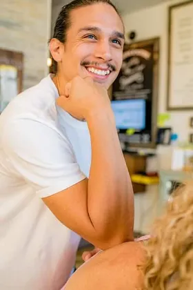 A person with smiling face wearing white shirt